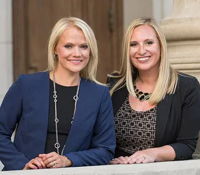 Kristen Wolf and Shari-Lynn Cuomo Shore smiling side-by-side outdoors.