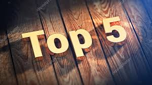 The bold text Top 5 written in large golden letters resting at an angle across dark wooden floorboards under a warm spotlight.